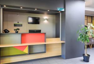 an office lobby with a colorful reception desk at B&B HOTEL Dijon Les Portes du Sud in Marsannay-la-Côte