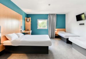 a hotel room with two beds and a window at B&B HOTEL Montpellier Centre Le Millénaire 3 étoiles in Montpellier