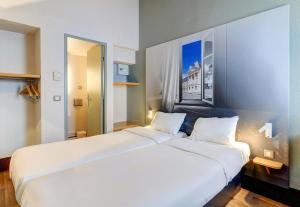a bedroom with a large white bed in a room at B&B HOTEL Dijon Marsannay in Marsannay-la-Côte