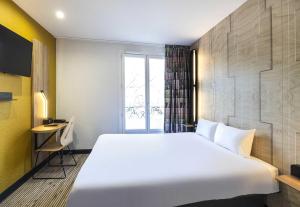 a large white bed in a room with a window at B&B HOTEL Perpignan Centre in Perpignan +26 photos