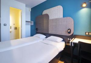 two beds in a room with blue walls at B&B HOTEL Avignon 1 in Le Pontet