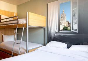 a room with two bunk beds and a window at B&B HOTEL Avignon 2 in Le Pontet