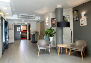 a waiting room with two chairs and a table at B&B HOTEL Avignon 2 in Le Pontet +24 photos