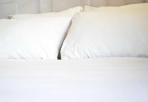 two white pillows sitting next to each other on a bed at B&B HOTEL Hasselt in Hasselt +3 photos