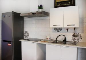 a kitchen with white cabinets and a stainless steel refrigerator at Diamante - relax nature , WiFi in Arcumeggia