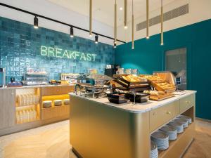 a breakfast restaurant with a counter with food at B&B HOTEL Namur in Namur