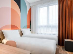 a hotel room with two beds and a window at B&B HOTEL Namur in Namur