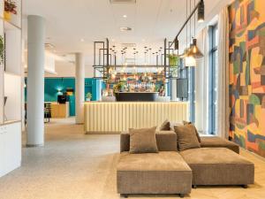 a living room with a couch and a bar at B&B HOTEL Namur in Namur +31 photos