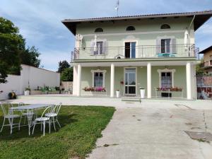 a large white house with a table and chairs at Kasa - B&B by Kristel in Maglione