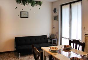 a living room with a black couch and a table at Diamante - relax nature , WiFi in Arcumeggia