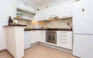 a kitchen with white cabinets and a white refrigerator at Apartman Maledi in Baška +13 photos
