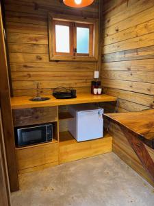 a small kitchen with a sink and a microwave at Cinque chalé in São Roque +11 photos