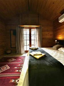 a bedroom with a large bed in a wooden room at Cinque chalé in São Roque