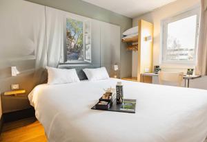 a bedroom with a large white bed and a desk at B&B HOTEL Rennes Est Cesson Sévigné 3 étoiles in Cesson-Sévigné