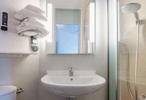 a bathroom with a sink and a mirror and a shower at B&B HOTEL Rennes Est Cesson Sévigné 3 étoiles in Cesson-Sévigné +21 photos
