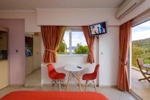 a living room with a table and two chairs and a television at Ktima Anastasia Olive Grove Nafplio in Nafplio