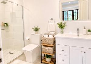 a white bathroom with a toilet and a sink at Bourne View in Nottingham Road +12 photos