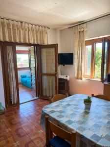 a dining room with a table and a living room at La Vela Apartment in Stintino