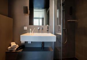 a bathroom with a white sink and a shower at B&B HOTEL St Gallen in St. Gallen