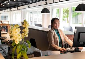 a woman sitting at a desk in front of a computer at B&B HOTEL St Gallen in St. Gallen