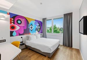 a hotel room with a bed and a tv at B&B HOTEL St Gallen in St. Gallen