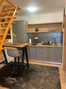 a kitchen with a wooden table and a sink at Lucy’s apartment in Osijek +15 photos