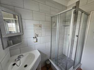 a bathroom with a shower and a sink at PhysEQFiT Guesthouse in Centurion