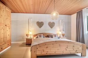 a bedroom with a wooden bed with two hearts on the wall at Eifelraum-Relaxwohnung mit Sauna in Oberbettingen