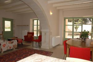 a living room with red chairs and a table at Villa Verde Petra in Arménoi