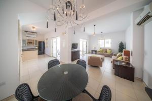 a dining room and living room with a table and chairs at La Villa - Protaras in Paralimni