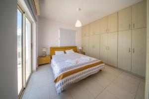 a bedroom with a bed and a large window at La Villa - Protaras in Paralimni
