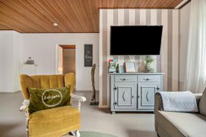 a living room with a chair and a television at Eifelraum-Relaxwohnung mit Sauna in Oberbettingen