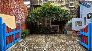 an entrance to a building with a blue gate with an orange tree at 鹿港,遇見1952-包棟 in Lukang +24 photos
