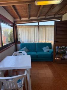 a living room with a blue couch and a table at La Vela Apartment in Stintino