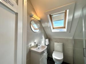 a bathroom with a toilet and a sink and a window at 14 Leitirshask, Ballyconneely in Ballyconneely +57 photos