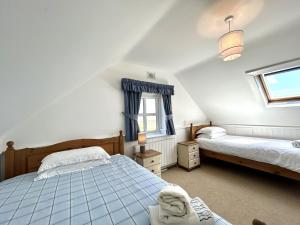 a attic bedroom with two beds and a window at 14 Leitirshask, Ballyconneely in Ballyconneely