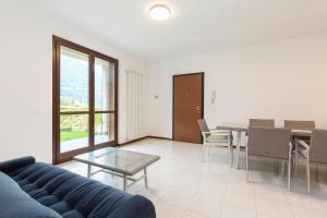 a living room with a blue couch and a table at Residence Borgo Castello B1 Apartment in Argegno +18 photos