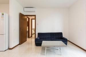 a living room with a blue couch and a table at Residence Borgo Castello B1 Apartment in Argegno