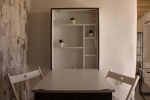 a table with two chairs and a shelf with plants at Litharaki Guest House in Ano Syros +15 photos