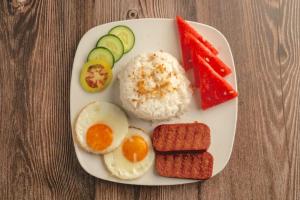 a plate of breakfast food with eggs rice and vegetables at Tom's Cabin Hotel in Cebu City
