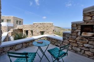 a patio with two chairs and a table at Koumaros Cycladic Suites in Koumáros