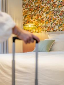 a person is standing next to a bed at Capucines Hotel Saint Tropez in Saint-Tropez +76 photos