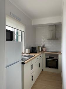a kitchen with white cabinets and a white refrigerator at Quinta do Avô Brum in Flamengos +36 photos
