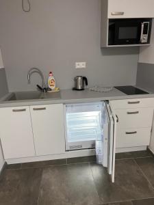 a small kitchen with a refrigerator and a sink at Centrum Apartman LEYLA 7 in Bardejov +5 photos