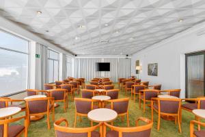 ein Zimmer mit Tischen und Stühlen und einem Fernseher in der Unterkunft Hotel Tigaiga in Puerto de la Cruz
