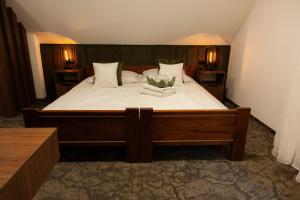 a bedroom with a large bed with white sheets at Zajazd U Dudziarza in Kościan