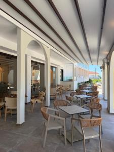 ein Essbereich mit Tischen und Stühlen sowie eine Cafeteria in der Unterkunft Noema Hotel in Syvota