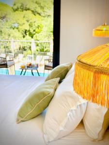 a bedroom with a bed with pillows and a balcony at Capucines Hotel Saint Tropez in Saint-Tropez