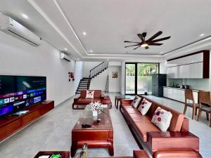 a living room with couches and a large tv at Flamingos Hải Tiến LUXURY view biển tầng cao và Biệt thự 4pn in Thanh Hóa