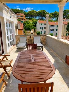 a wooden table and chairs on a balcony at Losinj Panorama Penthouse in Mali Lošinj